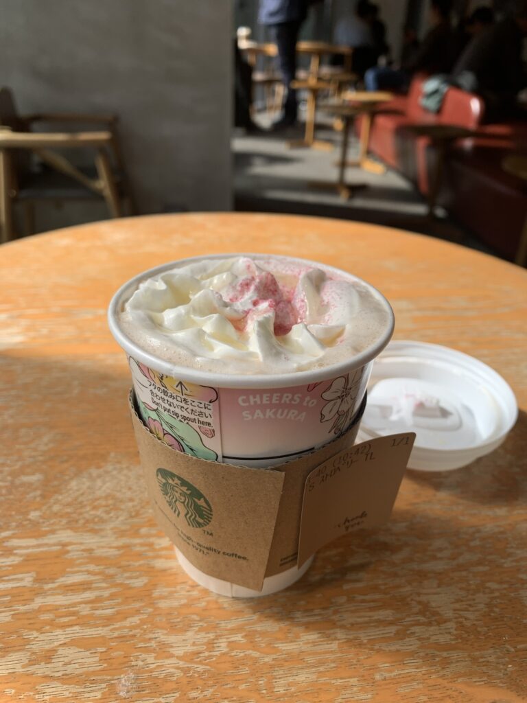 En kop Starbucks lavendel the med flødeskum og sakura tema på en Starbucks i Tokyo