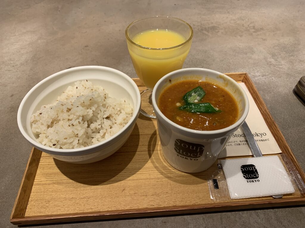 Suppe, ris og appelsin juice på træbakke fra Tokyo Soup kitchen
