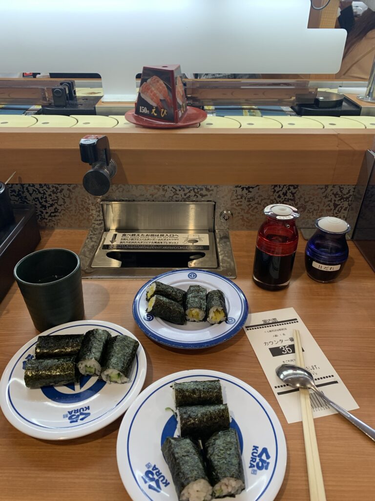 Runnig sushi ved Kura Sushi i Japan, sushiruller med agurk og daikon