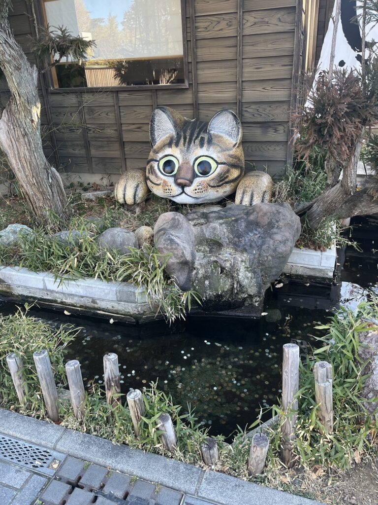 En kattefigur over en dam med mønter i Kawagoe