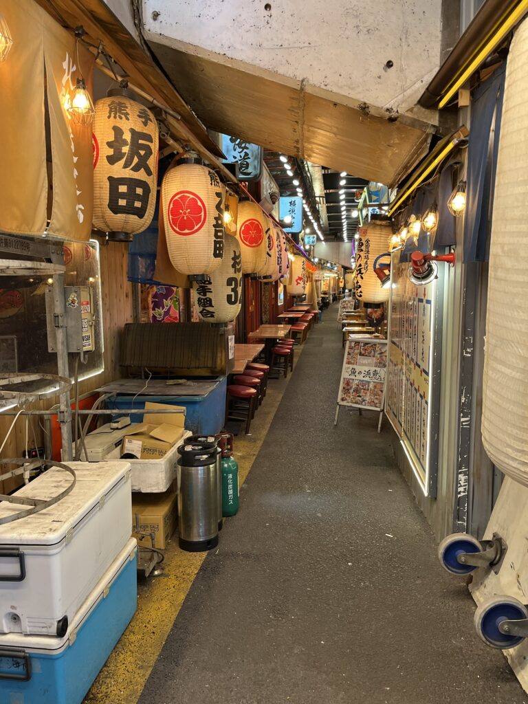 Lille gyde ved togstation i Tokyo med spisesteder og store hvide lanterner med røde skrifttegn